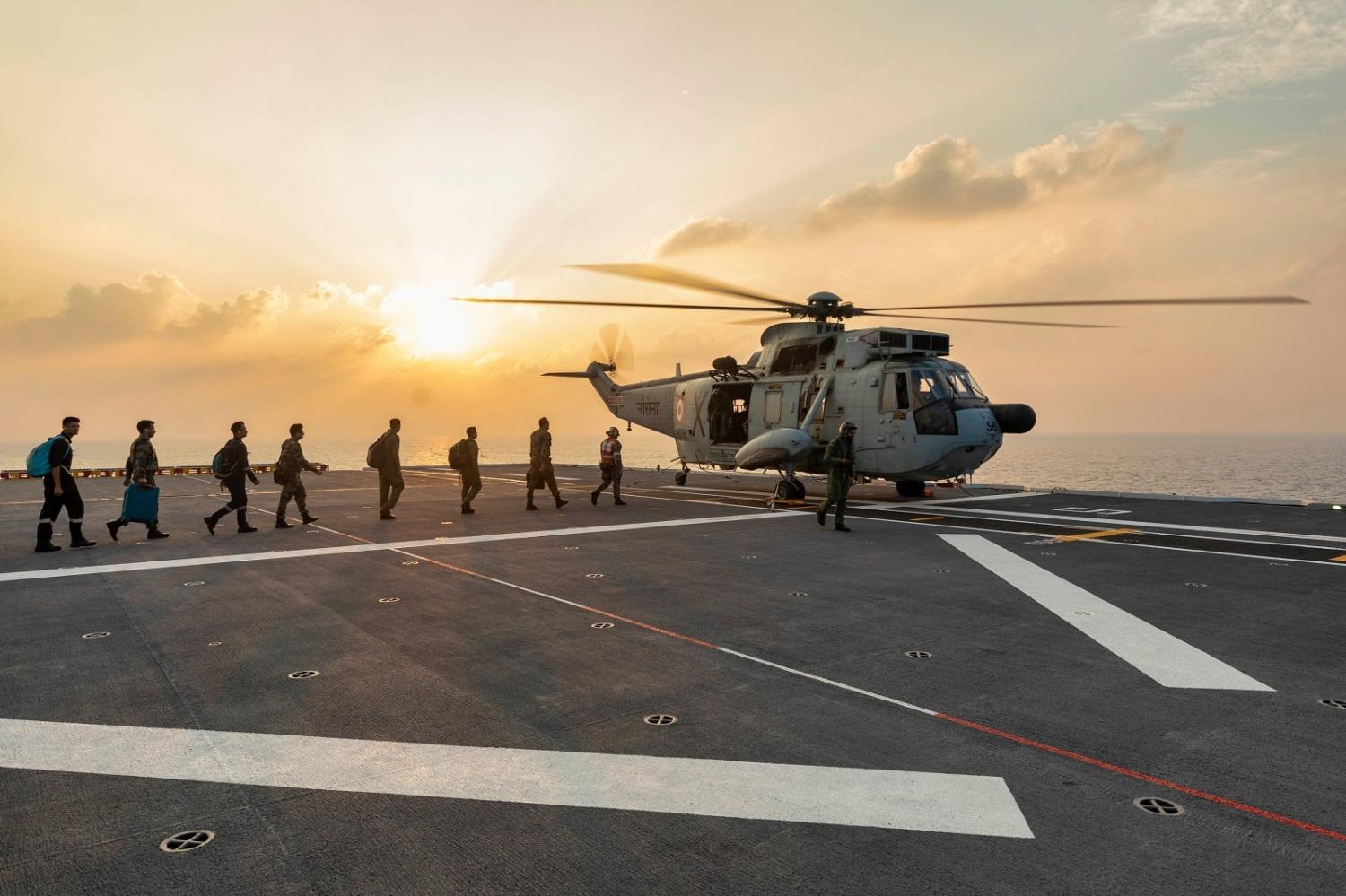 Indian Navy personnel on the flight deck of HMAS Adelaide boarding an Indian Navy UH-3H Sea King helicopter on Indo-Pacific Endeavour 2022 (Sittichai Sakonpoonpol/Defence Images)